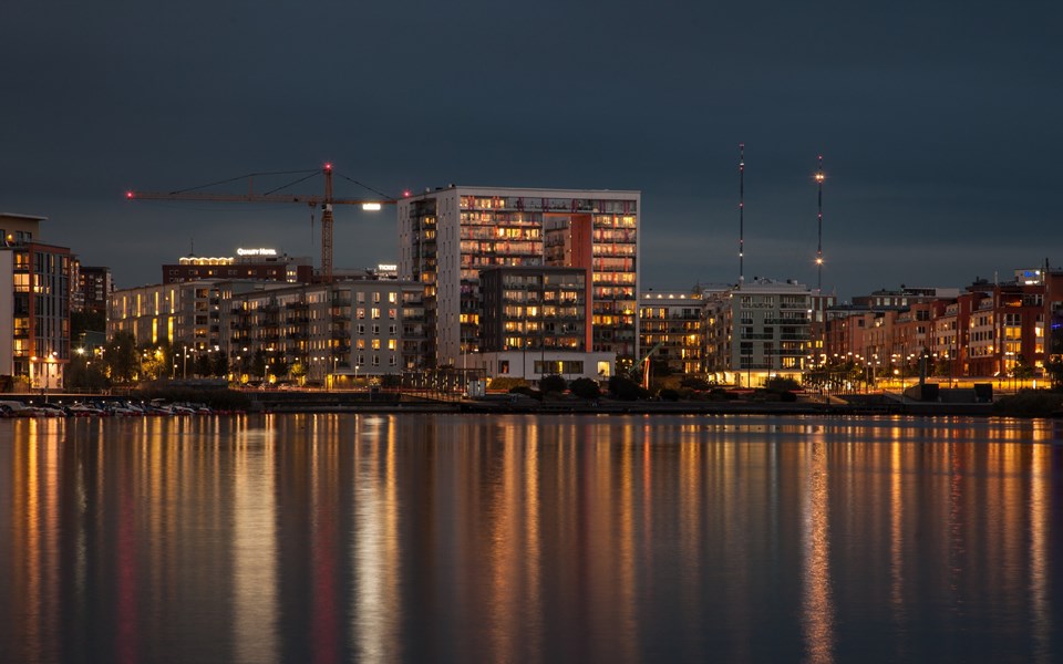 Kvällsvy över bostadshus i Hammarby sjöstad vid vattnet. Foto